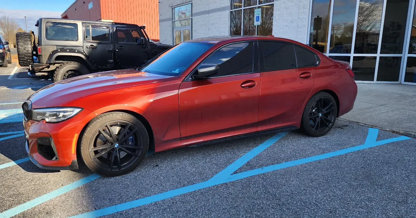 Orange BMW M340i outside the shop