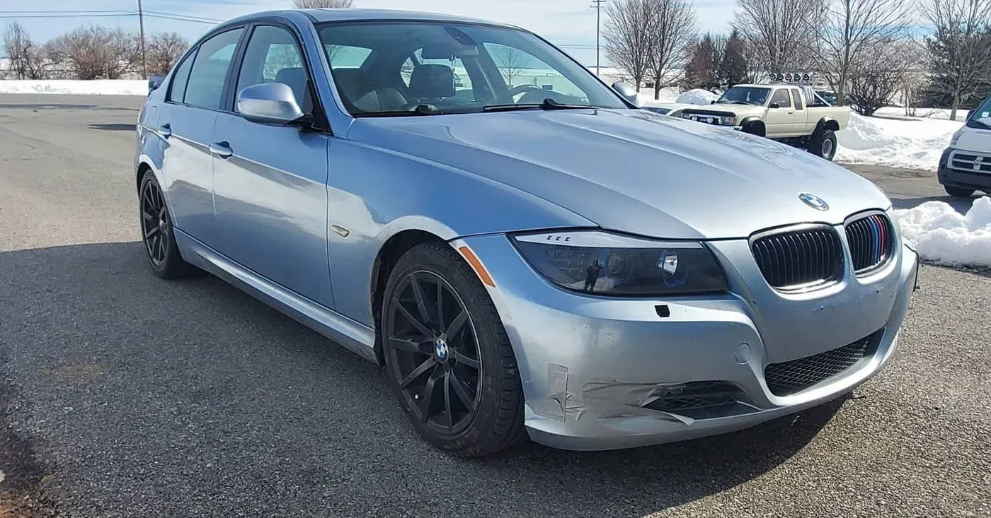 Silver BMW E90 328i outside the shop
