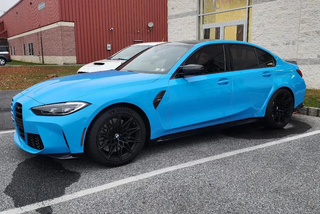 Blue BMW G80 M3 outside the shop
