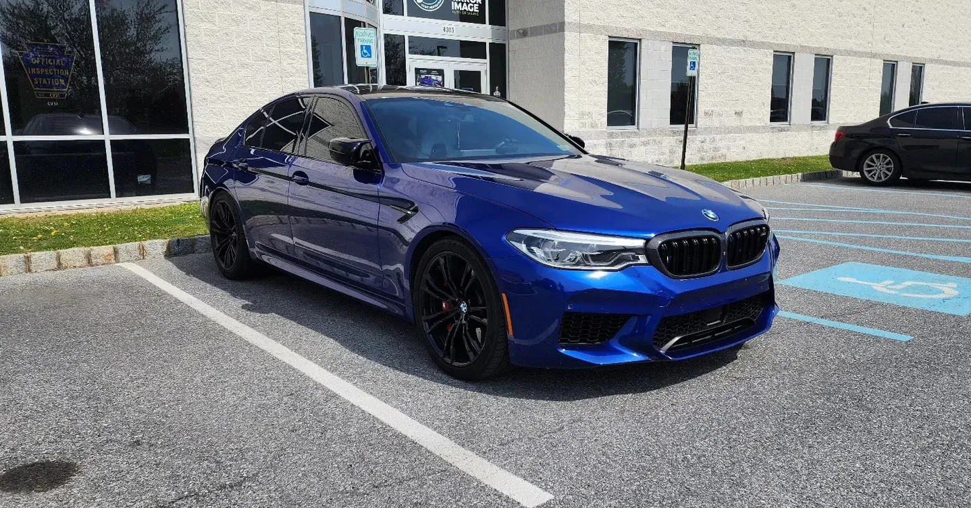 Blue BMW F90 M5 outside the shop