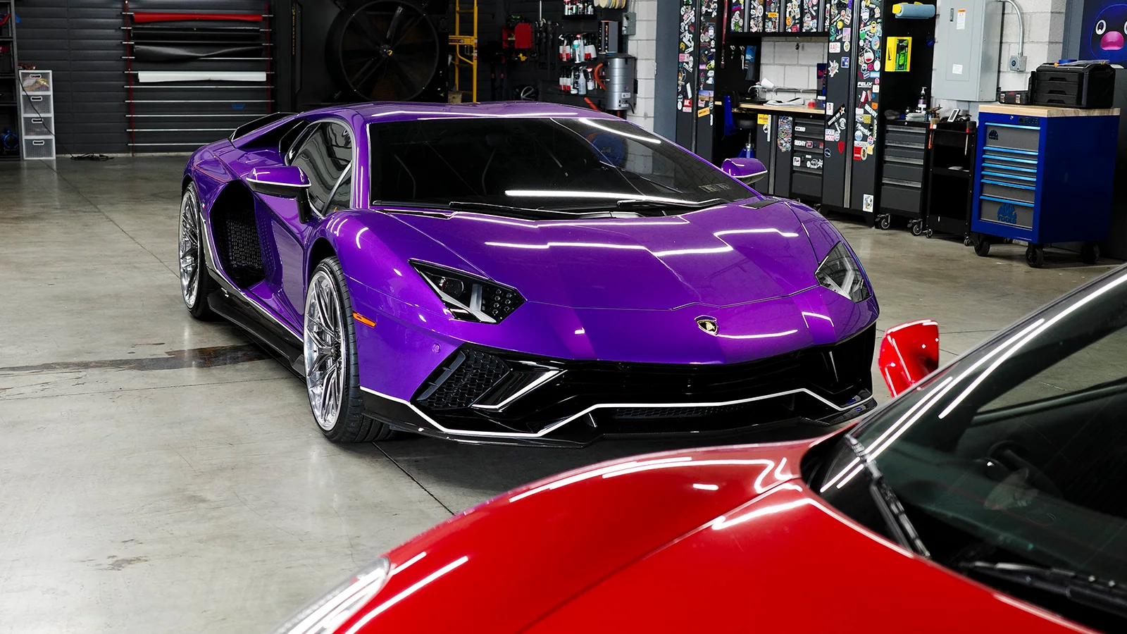 Lamborghini and Ferrari vehicles in the service bay at Vollux Autowerks