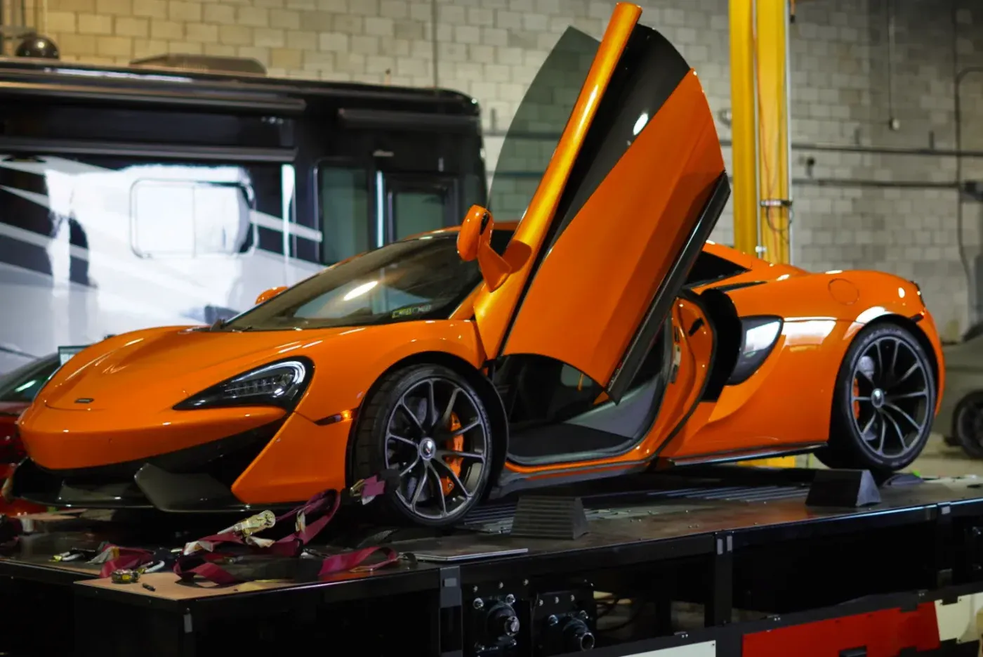 Orange McLaren 570S on the dyno with its doors raised