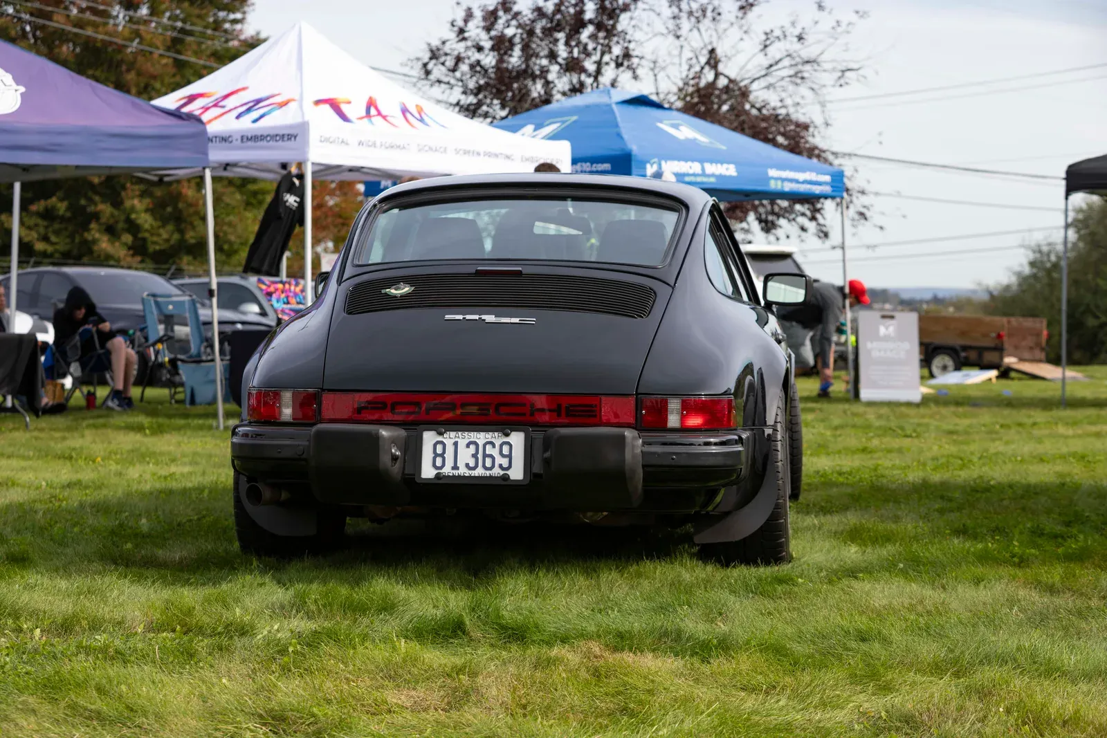 A classic Porsche parked on the lawn.