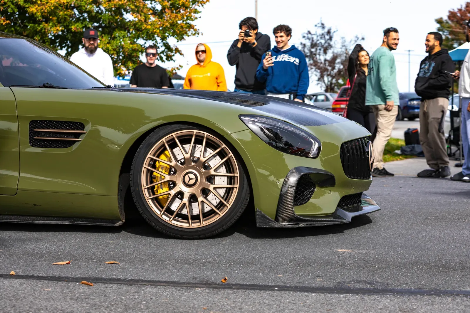 A green Mercedes and its bronze wheels draw a crowd.