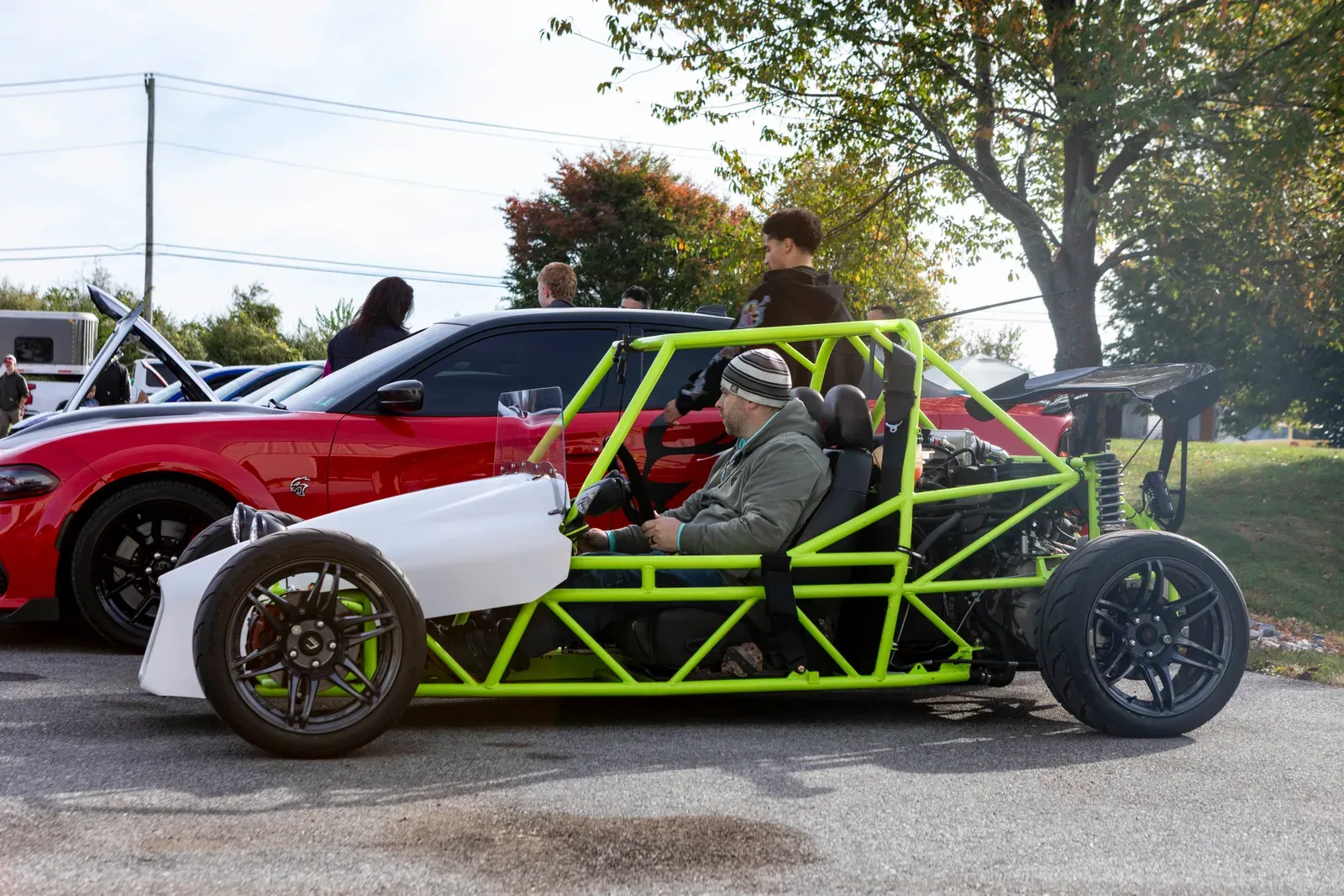 A green open-frame car among the day's arrivals.