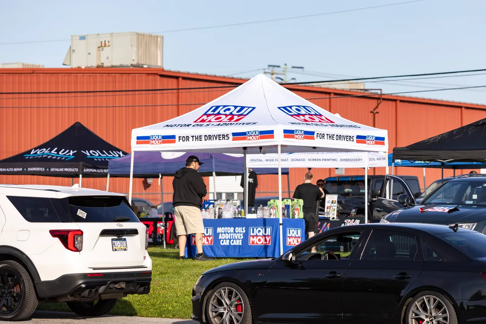 The Liqui Moly tent beside cars and vendor displays.