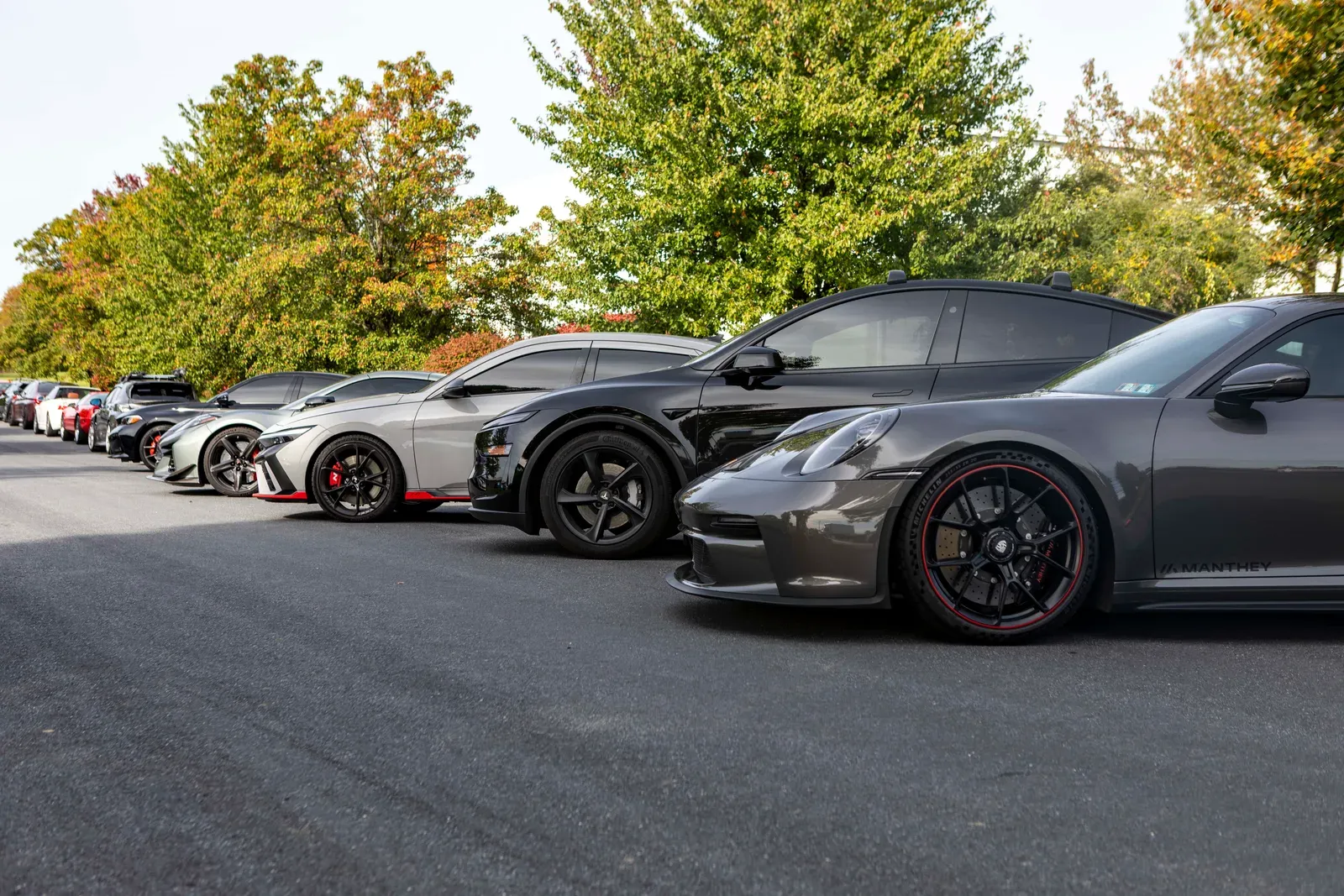 Performance cars lined up across the Vollux parking lot.