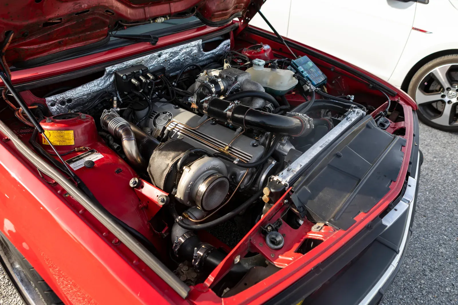 A look under the hood of the red BMW.