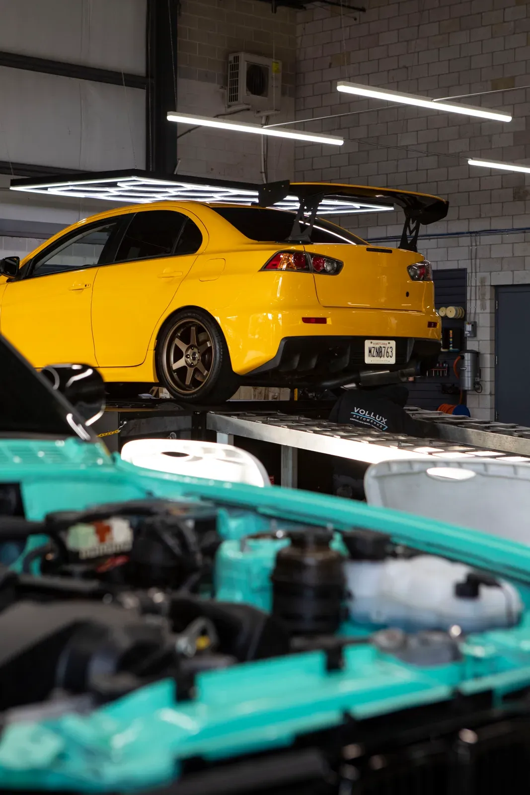 Cars on lifts inside the Vollux shop.
