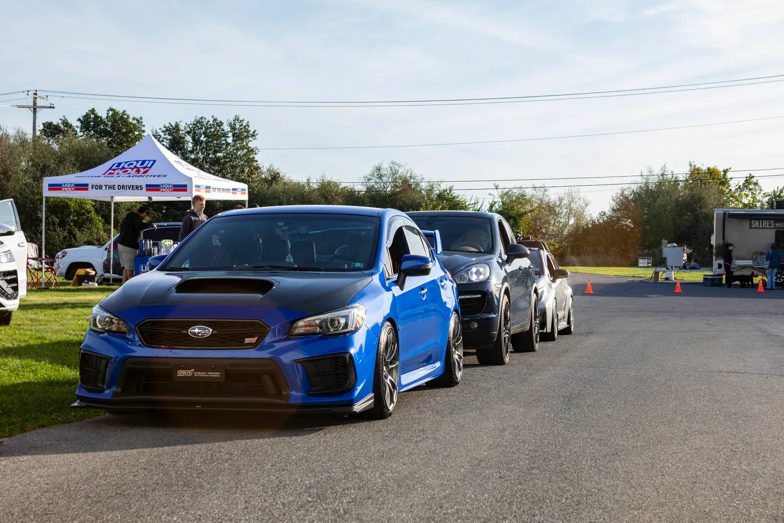A blue Subaru at the front of the arrival lineup.