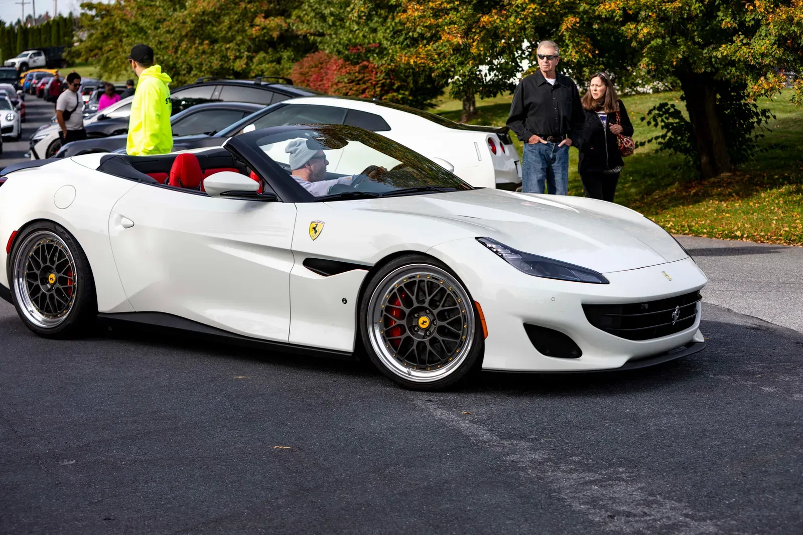 A white Ferrari convertible in the parking lot.